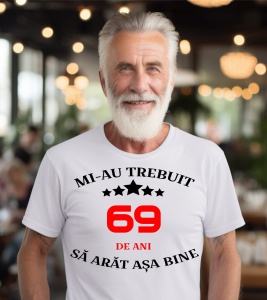 Un bărbat purtând un tricou alb cu mesajul: „Mi-au trebuit 69 de ani să arăt așa bine”