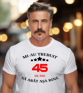 Un bărbat purtând un tricou alb cu mesajul: „Mi-au trebuit 45 de ani să arăt așa bine”