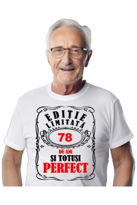 Un bărbat purtând un tricou alb cu mesajul: „Ediție limitată, 78 de ani și totuși perfect”. Bărbatul afișează o atitudine veselă și pozitivă.