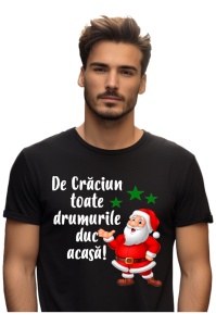 Bărbat purtând un tricou negru cu un design de Crăciun care include imaginea lui Moș Crăciun zâmbitor și textul ‘De Crăciun toate drumurile duc acasă!’, alături de trei steluțe verzi.
