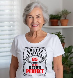 Femeie care poartă un tricou alb personalizat cu mesajul: ''85 de ani si totusi perfect''.