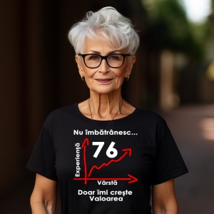 Femeie care poartă un tricou negru personalizat cu mesajul: ''Nu imbatranesc (76), doar imi creste valoarea''.
