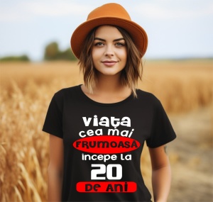 Femeie care poartă un tricou negru personalizat cu mesajul: ''Viata cea mai frumoasa incepe la 20 de ani''.