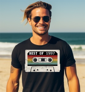 Un bărbat zâmbitor purtând un tricou negru cu o imagine stilizată a unei casete audio și textul ''Best of 1997''.