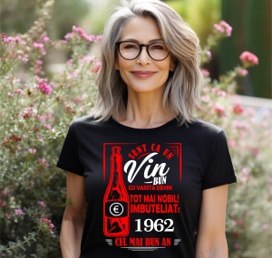 Femeie zâmbitoare purtând un tricou negru cu un mesaj în română despre vin, în care se menționează că este ca un vin bun care devine mai nobil cu vârsta, îmbuteliat în 1962, cel mai bun an.