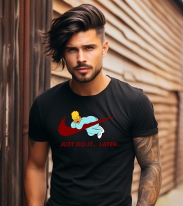 Bărbat cu păr lung, tatuaje și tricou negru cu un design ce include un logo stilizat și textul 'Just Do It... Later', pozând lângă o clădire din lemn.
