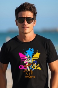 Bărbat cu părul închis la culoare, purtând un tricou negru cu un design colorat ce include personaje animate (Wile E. Coyote și Road Runner) și pete de vopsea roz, albastru și galben, pe un fundal de plajă.