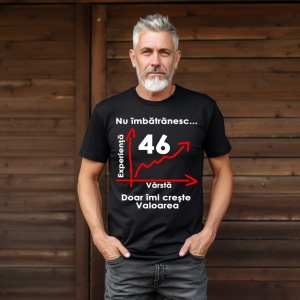 Un bărbat cu barbă albă purtând un tricou negru cu mesajul: „Nu îmbătrânesc... Doar îmi crește valoarea” și un grafic care indică vârsta de 46 de ani pe axa vârstei și experienței. Bărbatul se află într-un cadru simplu, cu un fundal întunecat.