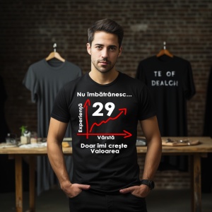 Un tânăr purtând un tricou negru cu mesajul: „Nu îmbătrânesc... Doar îmi crește valoarea” și un grafic care indică vârsta de 29 de ani pe axa vârstei și experienței. În fundal se află alte tricouri expuse într-o încăpere.