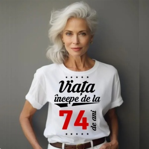 Femeie care poartă un tricou alb personalizat cu mesajul: ''Viața începe de la 74 de ani''