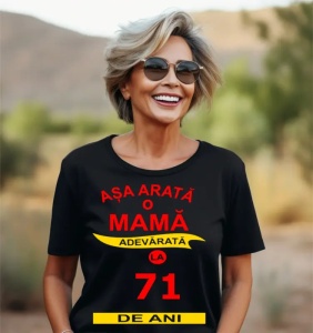 Femeie zâmbitoare purtând un tricou cu mesajul: ''Așa arată o mamă adevărată la 71 de ani''