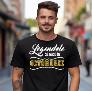 Un tânăr zâmbitor, cu părul aranjat, purtând un tricou negru cu mesajul: „Legendele se nasc în Octombrie”. Bărbatul se află pe o stradă urbană, cu clădiri și oameni în fundal.