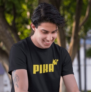 Un tânăr zâmbitor poartă un tricou negru cu textul 'PIKA' scris în galben și o siluetă stilizată a unui personaj celebru(Pikachu).