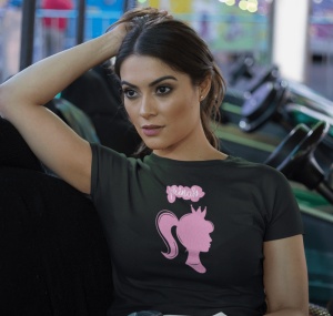 Tânără purtând un tricou negru cu un design roz care înfățișează silueta unei prințese cu o coroană și cuvântul 'princess' deasupra. Ea stă relaxată, sprijinindu-și o mână în păr, și privește concentrată într-o parte. Fundalul sugerează un loc de divertis