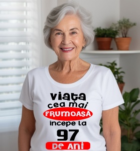 Femeie care poartă un tricou alb personalizat cu mesajul: ''Viata cea mai frumoasa incepe la 97 de ani''.