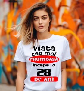 Femeie care poartă un tricou alb personalizat cu mesajul: ''Viata cea mai frumoasa incepe la 28 de ani''.