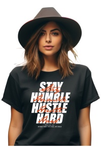 Femeie purtând un tricou negru cu mesaj motivațional 'Stay Humble Hustle Hard' scris în culori albe și portocalii, accesorizată cu o pălărie modernă.