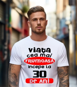 Un bărbat purtând un tricou alb cu textul ''Viața cea mai frumoasă începe la 30 de ani''.