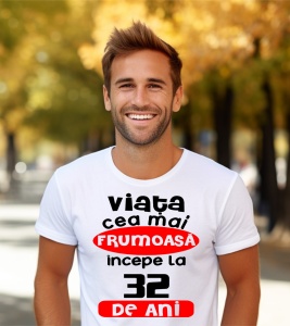 Un bărbat purtând un tricou alb cu textul ''Viața cea mai frumoasă începe la 32 de ani''.