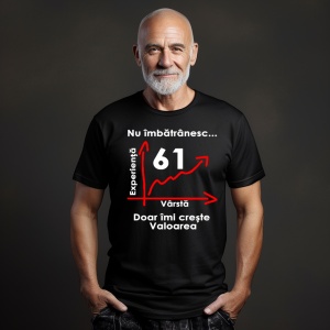 Un bărbat cu barbă albă și capul ras, purtând un tricou negru cu mesajul: „Nu îmbătrânesc... Doar îmi crește valoarea” și un grafic care indică vârsta de 61 de ani pe axa vârstei și experienței. Bărbatul se află într-un cadru simplu, cu un fundal întuneca