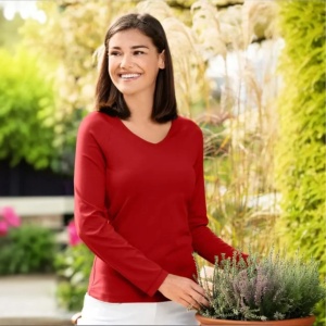 Bluza dama guler in v rosu purtata de o femeie frumoasa prezinta in natrura calitatea bluzei pentru femei de culoare rosu