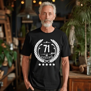 Un bărbat zâmbitor purtând un tricou negru cu textul ''71 de ani de excelență'', înconjurat de o coroană de lauri.