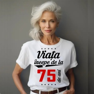 Femeie care poartă un tricou alb personalizat cu mesajul: ''Viața începe de la 75 de ani''