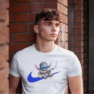 Tânăr purtând un tricou alb cu un personaj animat albastru(Stitch) cântând la chitară, situat deasupra unui logo stilizat albastru, stând lângă un zid de cărămidă roșie.