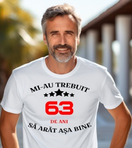 Un bărbat purtând un tricou alb cu mesajul: „Mi-au trebuit 63 de ani să arăt așa bine”
