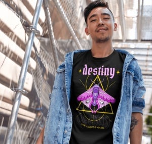 Un tânăr poartă un tricou negru cu un design mistic ce include cuvântul 'destiny' scris cu litere roz și o ilustrație detaliată a unui fluture colorat în nuanțe de mov și roz, în fața unei forme geometrice. Textul de jos spune 'The choice is yours'. Tânăr