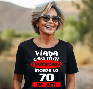 Femeie care poartă un tricou negru personalizat cu mesajul: ''Viata cea mai frumoasa incepe la 70 de ani''.
