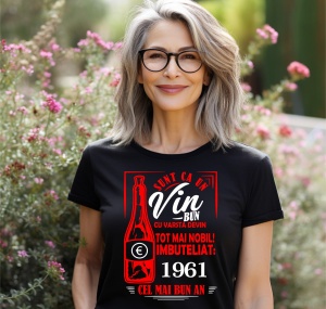 Femeie zâmbitoare purtând un tricou negru cu un mesaj în română despre vin, în care se menționează că este ca un vin bun care devine mai nobil cu vârsta, îmbuteliat în 1961, cel mai bun an.