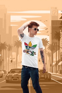 Tânăr cu păr roșcat, purtând ochelari de soare și un tricou alb cu un design grafic viu colorat, reprezentând un personaj animat și motive stilizate, aflat pe un fundal ilustrativ de oraș cu palmieri și mașini, sub un cer portocaliu vibrant.