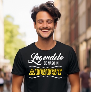 Un tânăr zâmbitor, cu părul aranjat, purtând un tricou negru cu mesajul: „Legendele se nasc în August”