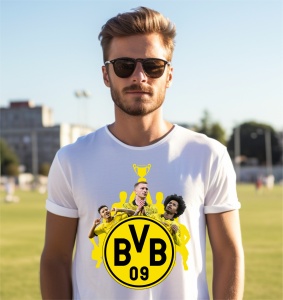 Un bărbat purtând un tricou alb cu design inspirat de Borussia Dortmund, ce include logo-ul BVB 09, un trofeu și imagini cu jucători ai echipei pe un fundal galben, pozând într-un mediu natural.