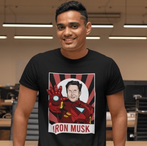 Bărbat zâmbitor purtând un tricou negru cu un design amuzant care îl arată pe Elon Musk îmbrăcat în costumul lui Iron Man, cu textul 'IRON MUSK' dedesubt, pe fundalul unui birou modern.