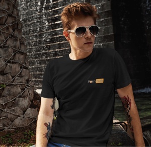 Un tânăr poartă ochelari de soare și un tricou negru cu un design inspirat de logo-ul 'Pornhub'. El are tatuaje pe brațul drept și stă într-un mediu urban, aproape de un perete și de un trunchi de palmier decorat cu sârmă.