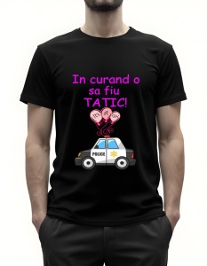 Bărbat purtând un tricou negru cu textul ‘În curând o să fiu tătic!’ în roz, cu ilustrația unei mașini de poliție și baloane roz cu mesajul ‘It's a girl!’