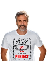Un bărbat purtând un tricou alb cu mesajul: „Ediție limitată, 61 de ani și totuși perfect”. Bărbatul afișează o atitudine veselă și pozitivă.