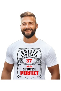 Un bărbat purtând un tricou alb cu mesajul: „Ediție limitată, 37 de ani și totuși perfect”. Bărbatul afișează o atitudine veselă și pozitivă.