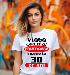 Femeie care poartă un tricou alb personalizat cu mesajul: ''Viata cea mai frumoasa incepe la 30 de ani''.