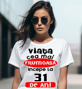 Femeie care poartă un tricou alb personalizat cu mesajul: ''Viata cea mai frumoasa incepe la 31 de ani''.