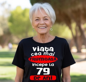 Femeie care poartă un tricou negru personalizat cu mesajul: ''Viata cea mai frumoasa incepe la 79 de ani''.