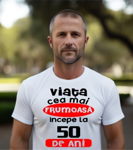 Un bărbat purtând un tricou alb cu textul ''Viața cea mai frumoasă începe la 50 de ani''.
