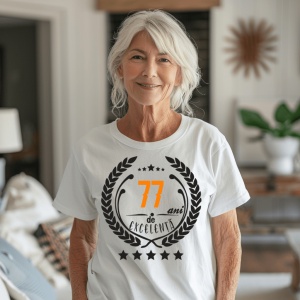Femeie zâmbitoare purtând un tricou personalizat cu mesajul: ''77 ani de excelenta''