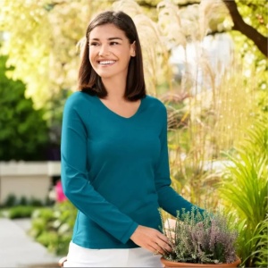 Bluza dama guler in v turcoaz inchis purtata de o femeie frumoasa prezinta in natrura calitatea bluzei pentru femei de culoare turcoaz inchis