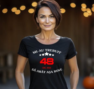 Femeie zâmbitoare purtând un tricou aniversar personalizat cu mesajul: ''Mi-au trebuit 48 de ani sa arat asa bine''