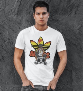 Bărbat îmbrăcat într-un tricou alb cu un design grafic vibrant, reprezentând un personaj urban așezat pe o boxă, cu un logo reinterpretat în culorile galben și roșu, pozând pe un fundal de textură gri.