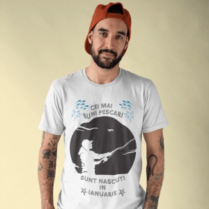 Imagine cu un bărbat purtând un tricou alb pe care este imprimat un design cu mesajul 'Cei mai buni pescari sunt născuți în ianuarie', cu o siluetă de pescar și ilustrații de pești.