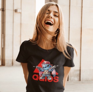 Fată zâmbitoare purtând un tricou negru cu un design grafic colorat ce înfățișează un personaj animat stilizat(Stitch) și un logo creativ în roșu, într-un cadru luminos și deschis.